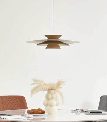 Suspension moderne au-dessus d'une table à manger avec des tons naturels chaleureux et un design intemporel.