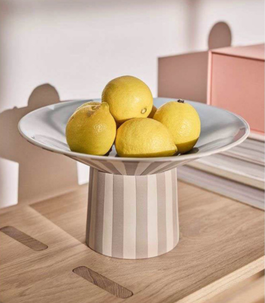 Bol OY OY Living avec des citrons sur une élégante table en bois dans des tons pastel doux.