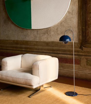 Élégant lampadaire &Tradition à côté d’un fauteuil lounge moderne dans un intérieur chaleureux.