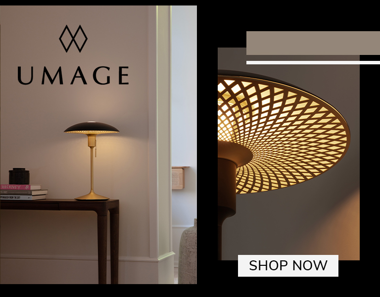 Shop now Elegant UMAGE table lamp with gold base and patterned shade on a wooden console table, softly illuminating a modern interior, with text ‘Shop Now’.